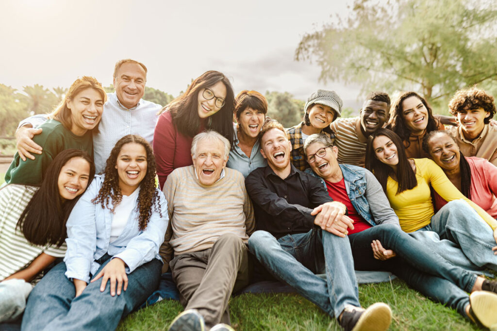 Group-of-people-at-a-park Large group of people sitting on the grass together, smiling.
